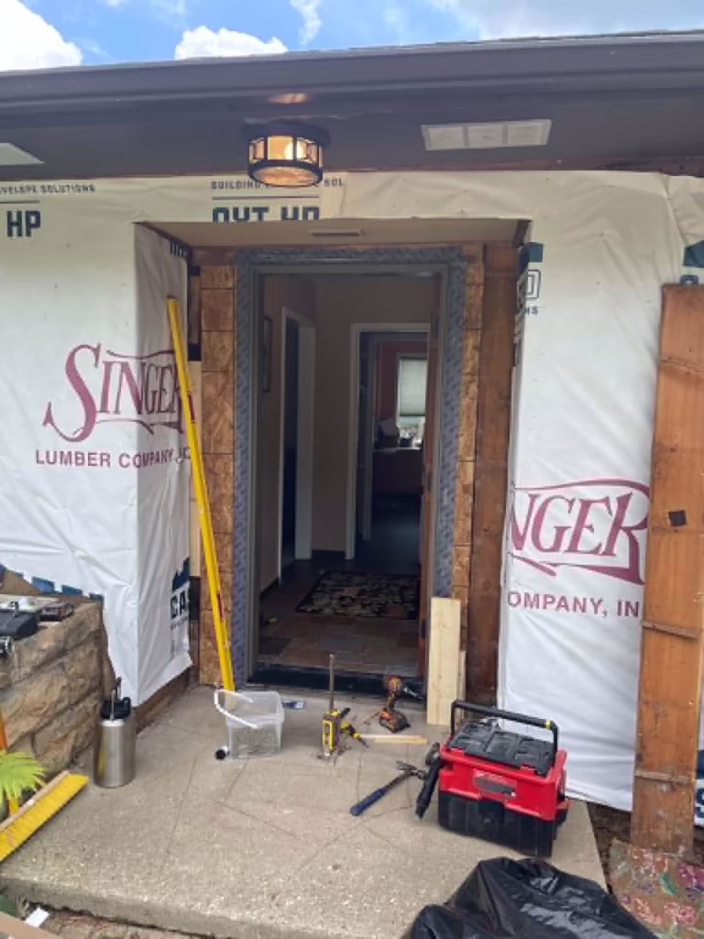 Front door removal — opening prepped with weather barrier