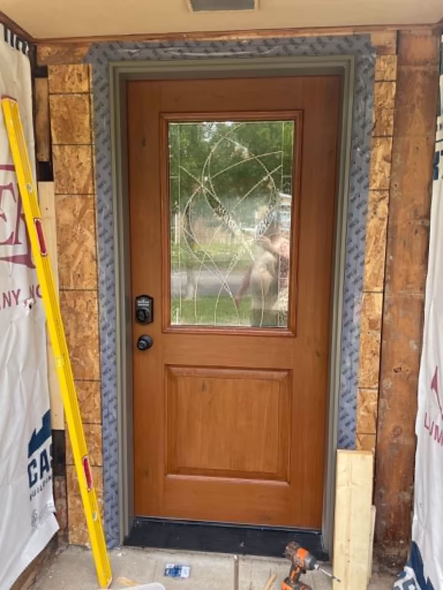 New front door installed with decorative glass and keypad lock